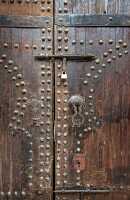 photo ornate old wooden door with metal design in Marrakesh Moro