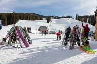 skiis and snowboards lined up at mountain resort in colorado