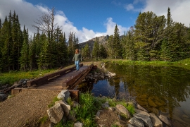 Vistor walking on bridge over stream in montana